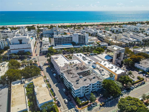 Aerial view of a coastal cityscape with multiple buildings and the ocean in the background.