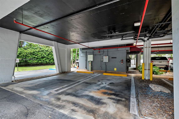 Covered parking area with painted lines and utility panels.
