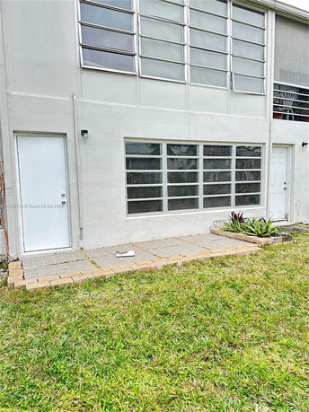 Rear view of a building with large windows and patio area.