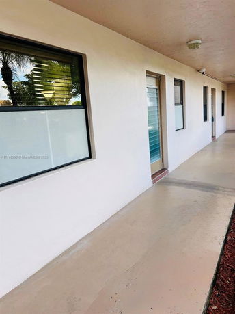 View of an outdoor walkway alongside a building with windows.