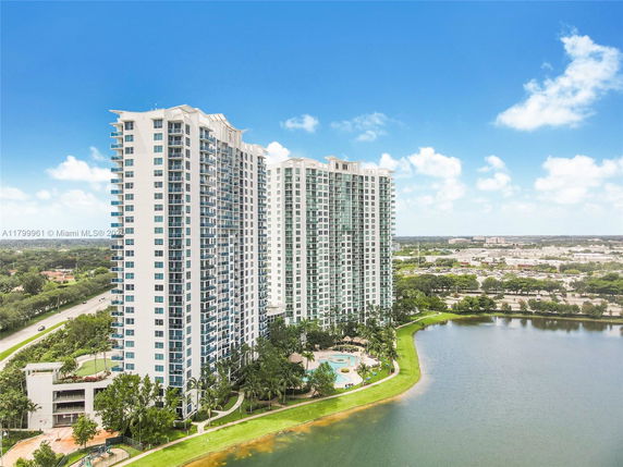 Front view of a tall, multi-story apartment building near a body of water.