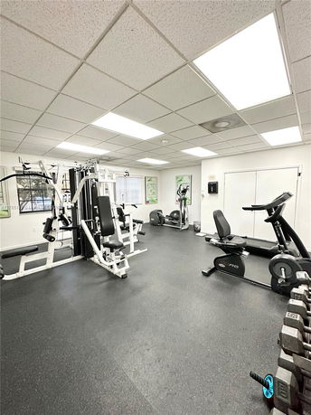 Interior view of a gym with exercise equipment and weights.