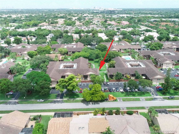 Aerial view of a residential area with multiple buildings and surrounding greenery.