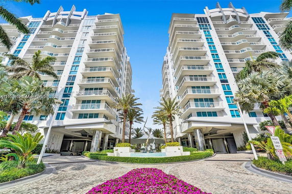 Front view of two modern multi-story buildings with balconies.