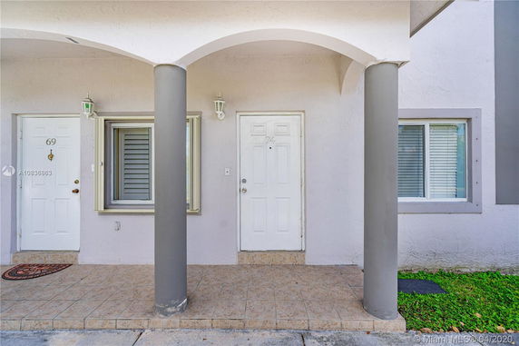 Front view of a building entrance with two doors and columns.