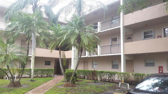 Front view of a multi-story apartment building with balconies.