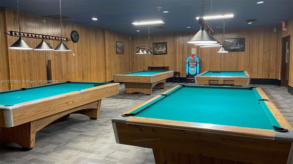 Room with multiple billiard tables and a jukebox.