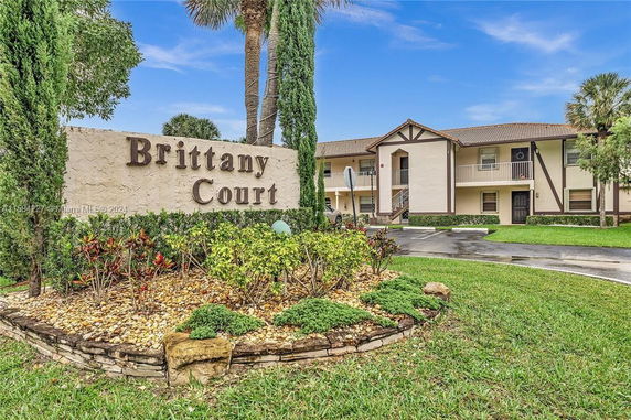 Front view of a residential building with a sign reading 'Brittany Court'.