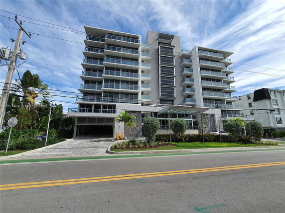 Front view of a multi-story apartment building with balconies.
