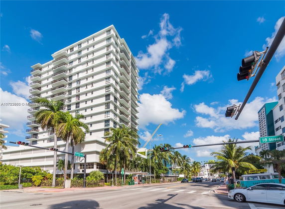 Front view of a multi-story residential building with balconies on each floor.