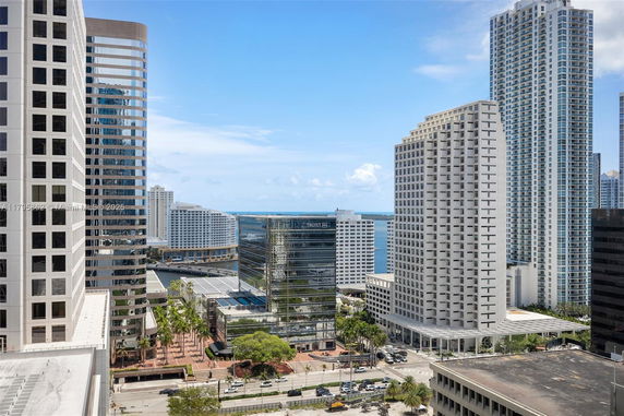 Panoramic view of multiple high-rise buildings in an urban area with a glimpse of water in the distance.