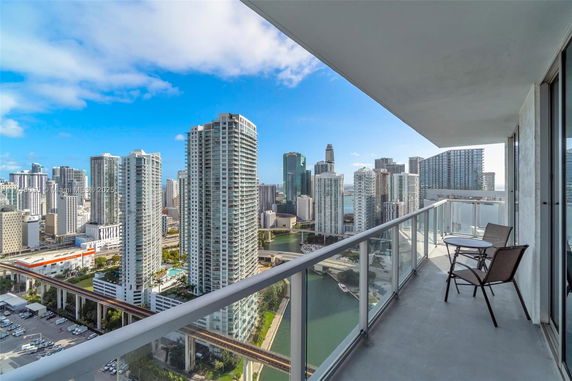View of cityscape with tall buildings from a balcony.