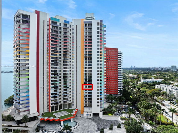 Front view of a colorful high-rise building with multiple balconies.