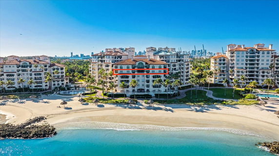 Front view of a beachfront multi-story residential building with balconies.