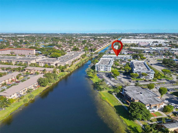 Aerial view of a residential area with multiple buildings near a body of water.