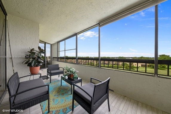 Balcony with patio furniture and a view of the surrounding landscape.