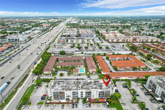 Aerial view of a residential and commercial area near a highway.