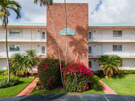 Front view of a multi-story residential building with a brick facade and balconies.