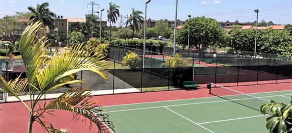 Outdoor tennis courts surrounded by trees.