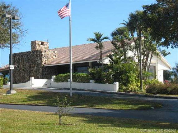 Front view of a single-story house with stone chimney and sloped roof.