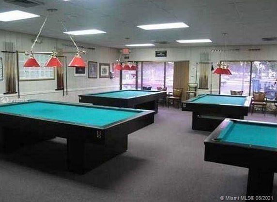 A recreation room with pool tables and red overhead lights.