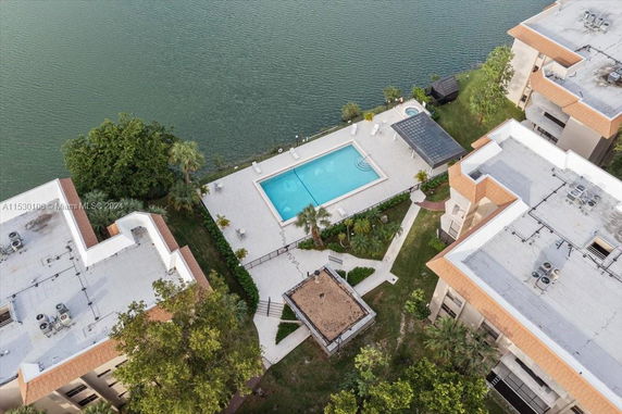 Aerial view of a swimming pool surrounded by buildings and water.