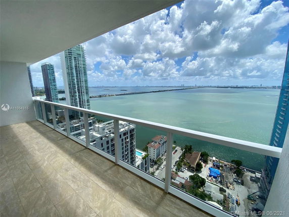 Panoramic view from a high-rise building balcony overlooking the ocean.
