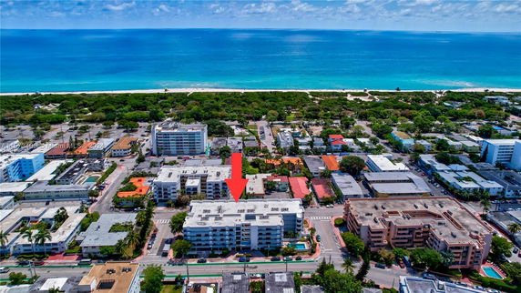Aerial view of a coastal residential area with multiple buildings near the ocean.