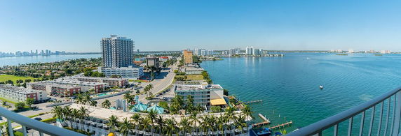 Panoramic view from a high-rise building overlooking water and cityscape.