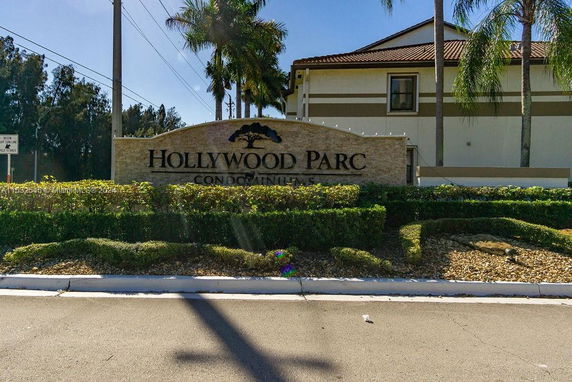 Front view of a condominium entrance with a sign reading 'Hollywood Parc Condominiums.'
