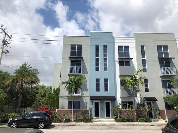 Front view of a modern multi-story building with balconies.