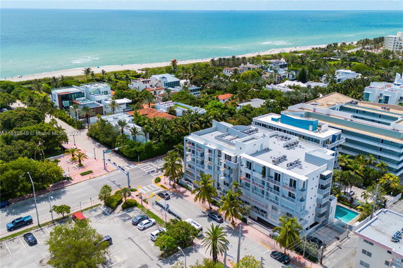 Aerial view of a coastal residential area with mid-rise buildings, roads, and proximity to the beach.