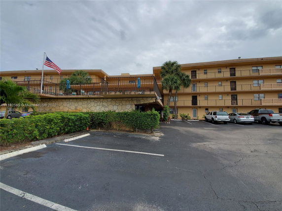 Front view of a multi-story building with parking area.