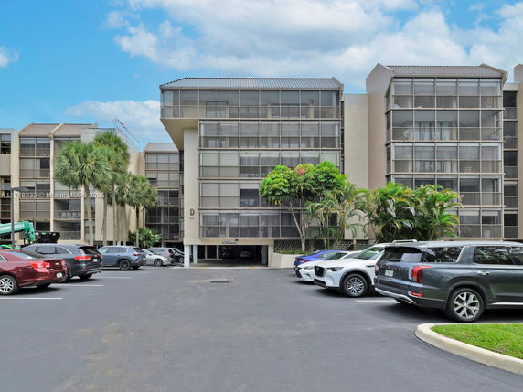 Front view of a multi-story building with a parking area in front.