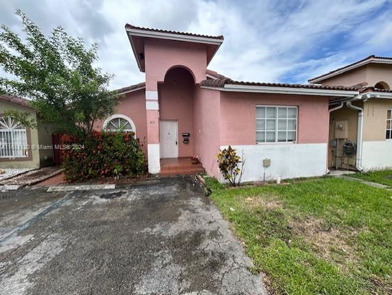 Front view of a single-story house with pink exterior walls and a tiled roof.