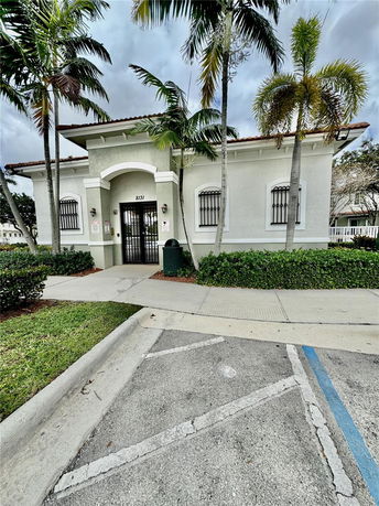 Front view of a single-story building with arched entrance and barred windows.