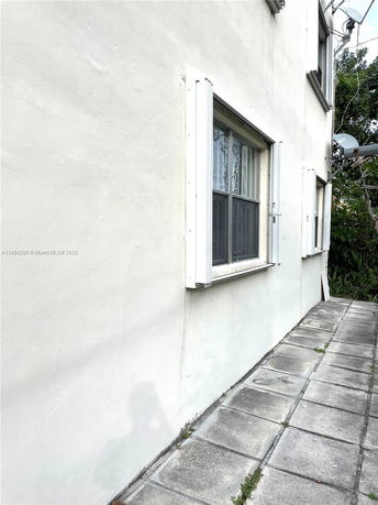 Side view of a building with windows and exterior shutters.