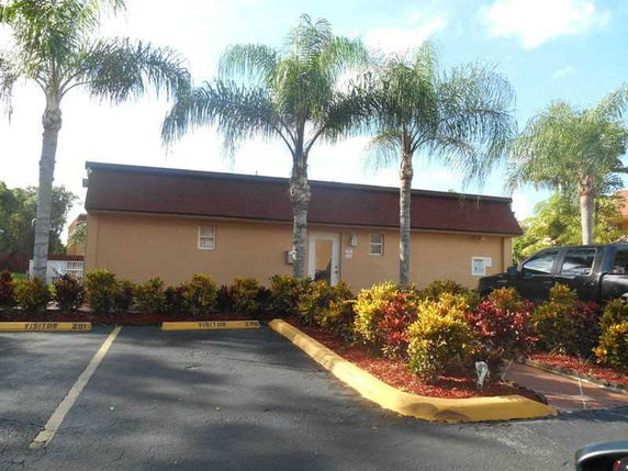 Front view of a single-story building with brown roof.