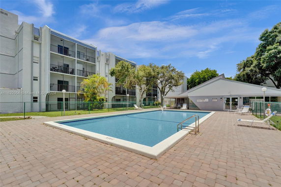 Outdoor swimming pool next to a multi-story residential building.