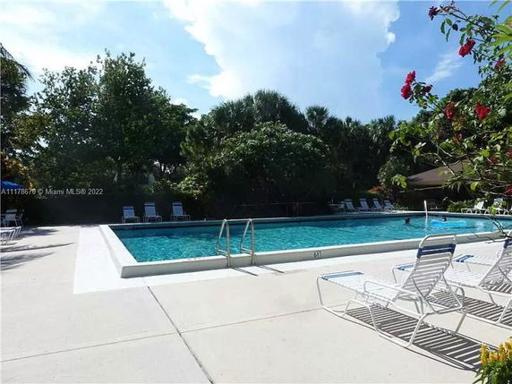 Outdoor swimming pool with lounge chairs surrounding it.