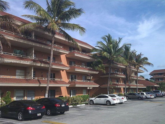 Front view of a multi-story apartment building with balconies.