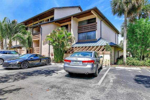 Front view of a building with parking area and parked cars