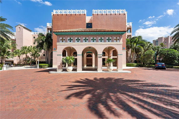 Front view of a multi-story building with arches and decorative elements.
