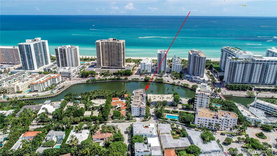 Wide angle view of coastal urban area with tall buildings and ocean in the background.