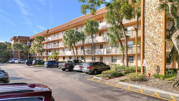 Parking area in front of a multi-story residential building.
