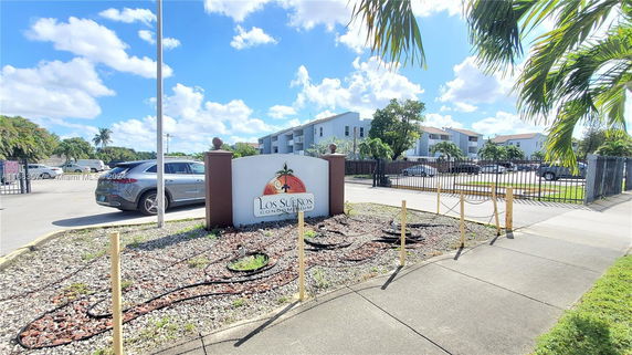 Front view of a condominium complex entrance with a sign reading 'Los Sueños Condominium'.