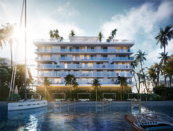 Front view of a multi-story building with balconies, surrounded by palm trees and water in the foreground.