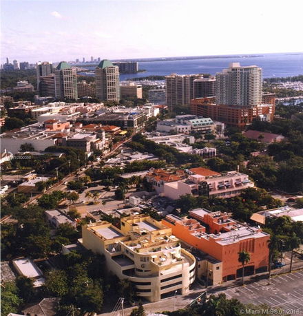 Aerial view of a cityscape with high-rise buildings and waterfront.