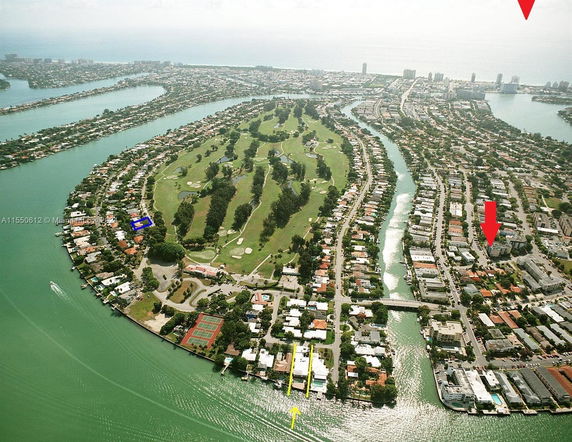 Aerial panoramic view of a coastal residential area with canals and a golf course.