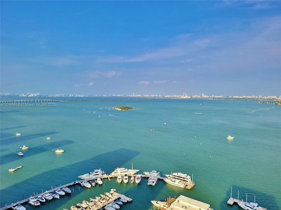 Panoramic view of a marina with boats and city skyline in the distance.